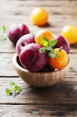 Sweet fresh black and yellow plums on the table