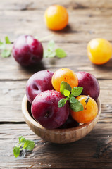 Sweet fresh black and yellow plums on the table