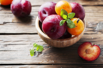 Sweet fresh black and yellow plums on the table