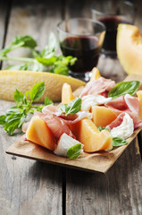 Antipasto with melon, mozzarella, ham and basil