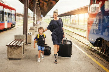 Cute little boy and mother on a railway station