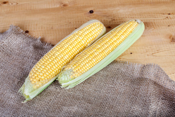 Fresh corn on cobs onrustic wooden table