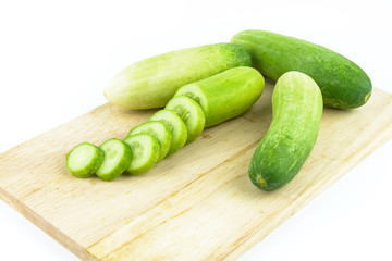Cucumber slices on cutting board on white background