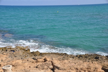 Fototapeta na wymiar playa El contrasteentrela roca volcánica y el mar, en un ambiente de relajación