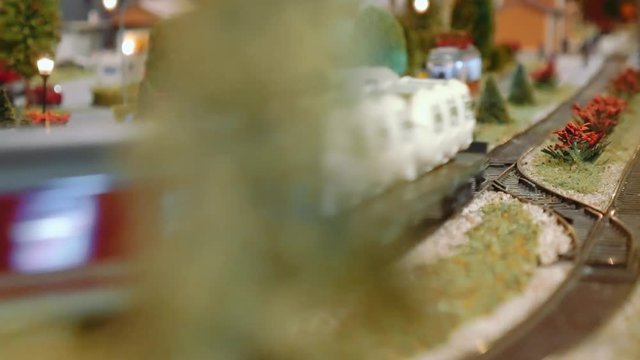 Model train passing behind a tree on a diorama
