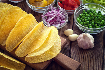 Mexican corn tortilla tacos with vegetables on wooden background