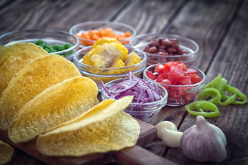 Mexican corn tortilla tacos with vegetables on wooden background