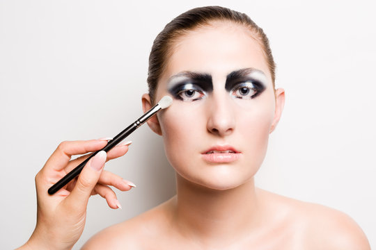Young girl model with striking dark smokey eyes make up. The make up is applied with a brush.
