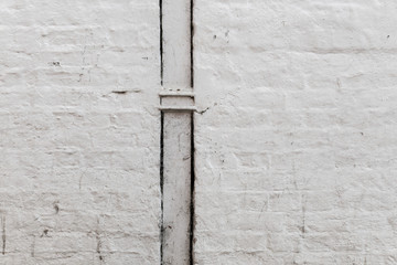 White painted brick wall with downpipe
