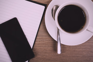 Notebook and coffee cup on a wooden surface Vintage Retro Filter