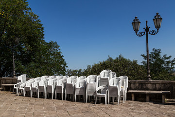 Stack of white plastic chairs for a local festival, Abruzzo, central Italy