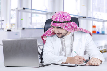 Muslim doctor with laptop in hospital