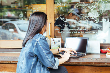 Fototapeta na wymiar Young asian woman wear jean shirt using laptop computer