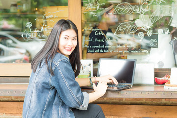 Young asian woman wear jean shirt using laptop computer