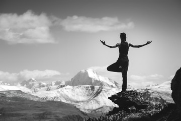 Woman trekking yoga mountains greyscale concept