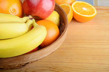 Basket of fruits on wooden table.
