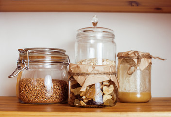 real comfort wooden kitchen with breakfast ingredients close up in glass, honey, oatmeal, milk, muesli