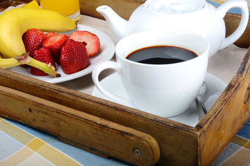 Breakfast tray with coffee, orange juice and fruits.