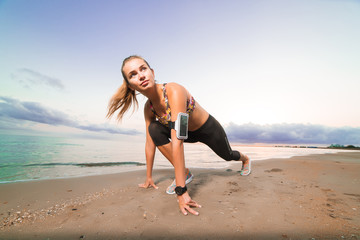 Fototapeta premium Cute fit girl starts running on beach at sunrise