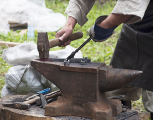 Blacksmith forges iron on the anvil