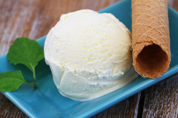 Scoop of home made creamy vanilla ice cream and crispy wafer, closeup
