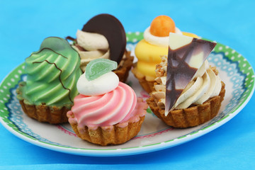 Selection of fresh cream cakes on blue background
