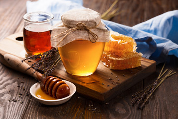 Honey in jar and bunch of dry lavender