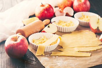 Baking Apple Pie Ingredients - fresh apples, flour, eggs and sugar on rustic dark background, selective focus. Toned image.