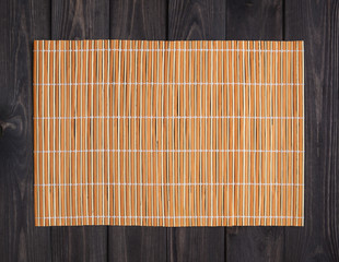 Bamboo mat on wooden table, top view