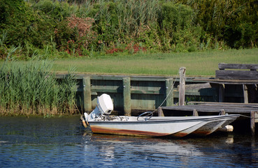 old fishing boat tied to small dock in the water
