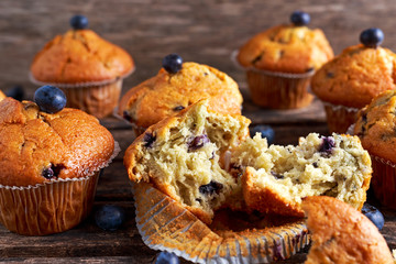Homemade Blueberry Muffins with fresh berries on wooden table.