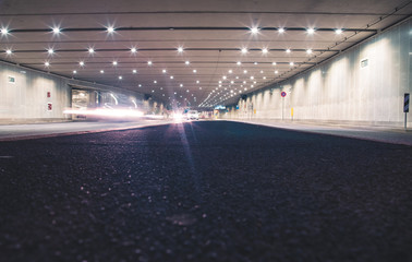 Fototapeta na wymiar Fast cars in a modern tunnel by night