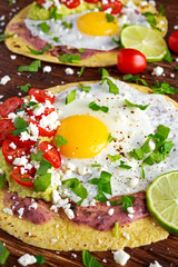 Huevos Rancheros Breakfast tostadas with avocado, feta cheese and vegetables.