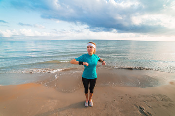 Young sporty girl doing workout on beach at sunrise in morning