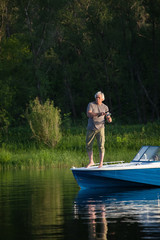 Mature man on a motor boat. Fishing