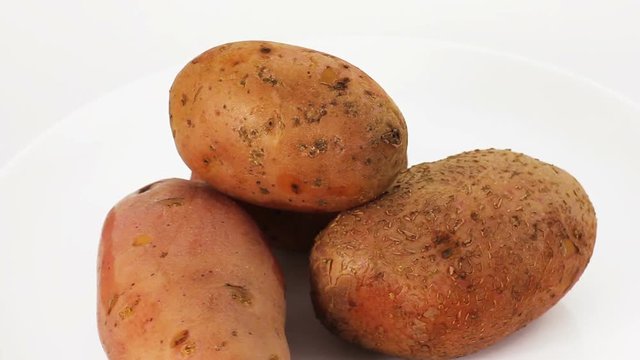 Video of fresh potatoes rotating at white background. Vegetable background.  Full Hd stock footage clip.

