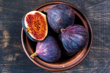 Ripe raw figs on a black wooden table, top view, copy space
