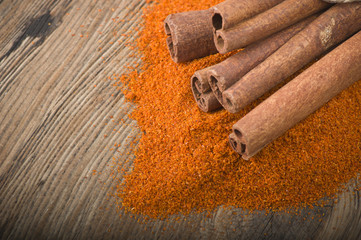 cinnamon sticks with powder on the wood table