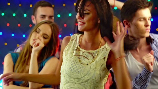 Girl with friends dancing in nightclub. 4k. Large group people have fun and dance in nightclub.