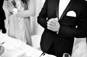 Wedding couple at the table on restaurant, hands folded for prayer