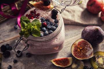 bright detox smoothie with berries on wooden background bowl