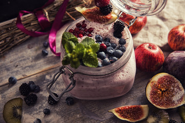 bright detox smoothie with berries on wooden background bowl