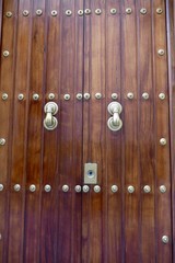 alte Holztür mit dekorativen Beschlägen und Türklinken