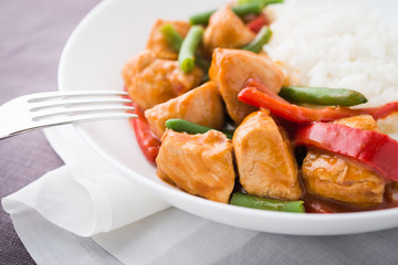Spicy chicken with vegetables ( green beans and red pepper) and rice. Oriental food.