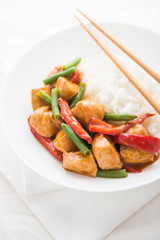 Spicy chicken with vegetables ( green beans and red pepper) and rice close up. Oriental food.