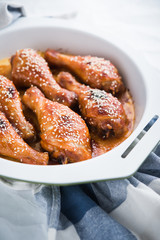 Baked spicy chicken legs with sesame close up.