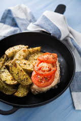 Dry basil parmesan fries and tomato chicken oven baked close up.