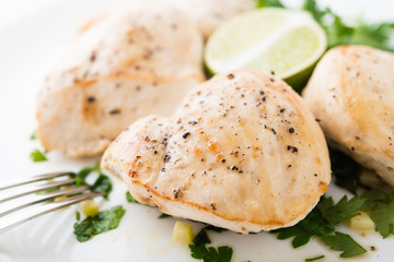 Chicken breasts with parsley and citrus on white background close up. Healthy food.