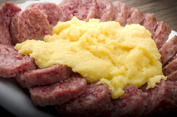 pork sausage (cotechino) with polenta on the wood table
