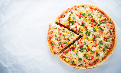 Sliced pizza with mozzarella cheese, chicken, sweet corn, sweet pepper and parsley on white background top view. Italian cuisine. Space for text.